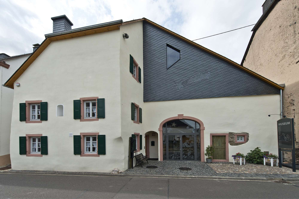 Das Gebäude, das heute das Krippenmuseum beherbergt, liegt im Ortskern von Klüsserath, einem typischen und traditionsreichen Winzerort an der Mosel, in der Nähe von Trier. Das um 1650 erbaute dreigeschossige Winzerhaus gilt als eines der letzten erhaltenen moselländischen Winkelhäuser und steht unter Denkmalschutz.