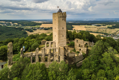 Gesamtanlage der Burg Olbrück mit Überresten der Außenmauern und erhaltenem Turm