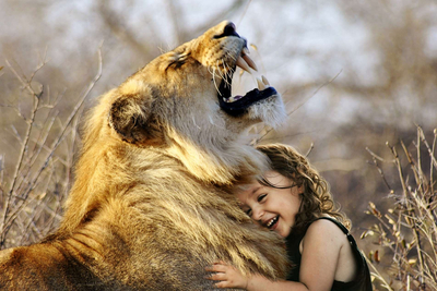 Ein kleines Mädchen kuschelt mit einem wilden Löwen.