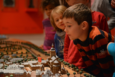Kinder betrachten ein Modell der historischen Simeonstiftskirche