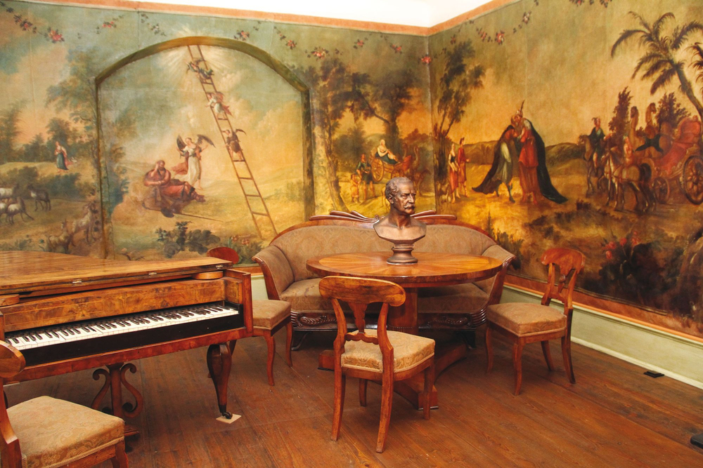 Historischer Wohnraum Blüchers mit Klavier, handbemalten Tapeten und Sitzgruppe