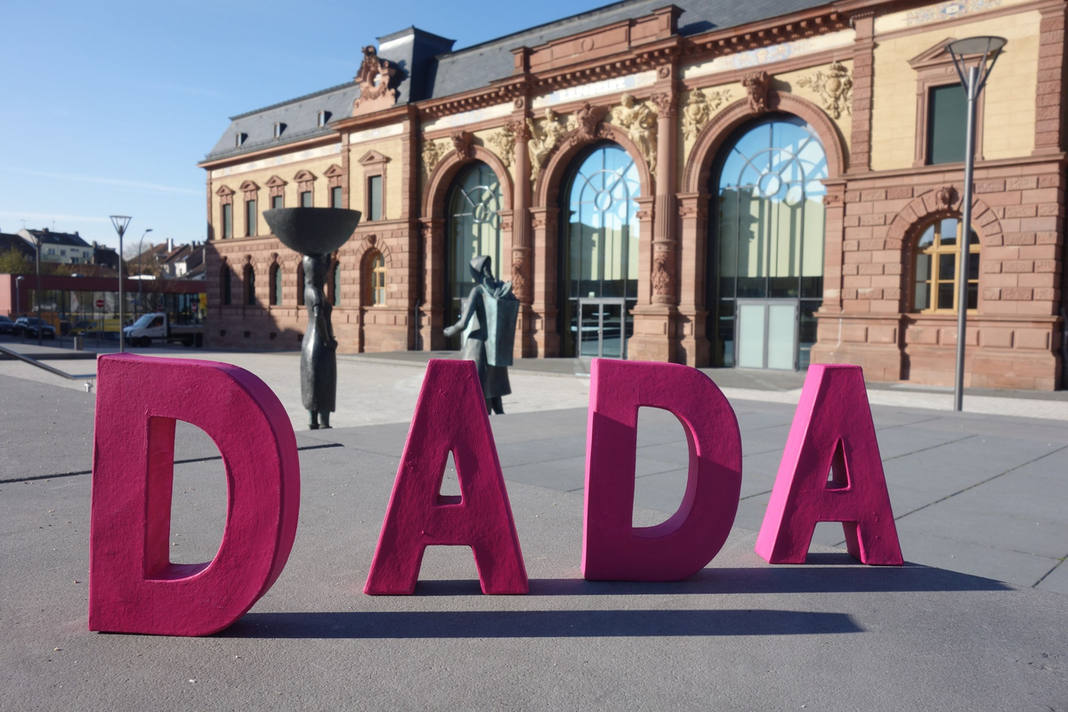 Das Wort DADA in plastischen, pinkfarbenen Buchstaben vor dem Forum Alte Post