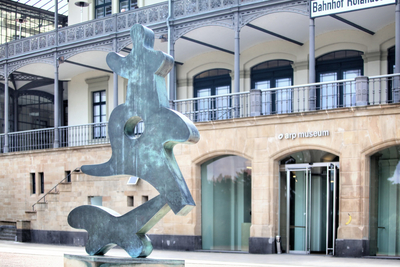 Vor dem Museumsgebäude steht eine Skulptur des Künstlers Hans Arp mit dem Titel "Bewegtes Tanzgeschmeide".;
